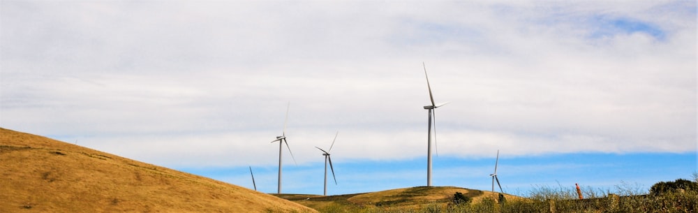 a group of wind turbines on a hill