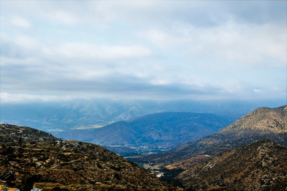 green and brown mountains under white clouds during daytime