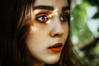 Portrait of a young woman with natural light highlighting her expressive eyes.
