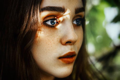 Portrait of a young woman with natural light highlighting her expressive eyes.