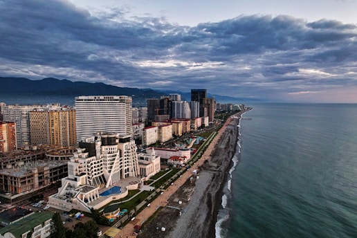 city skyline near body of water under cloudy sky during daytime