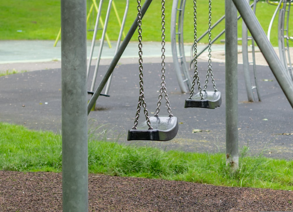 black and white swing on green grass field during daytime