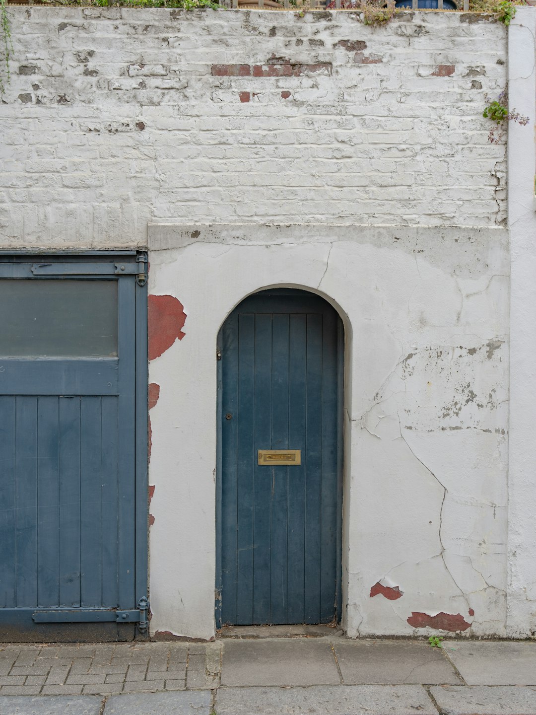 blue wooden door on white brick wall
