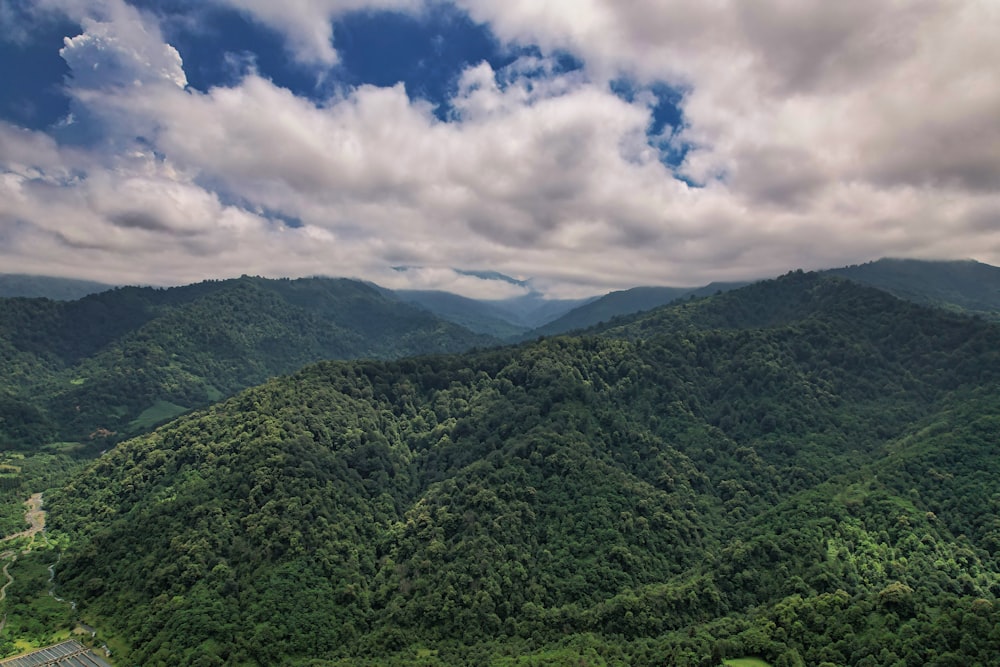 green mountains under white clouds and blue sky during daytime