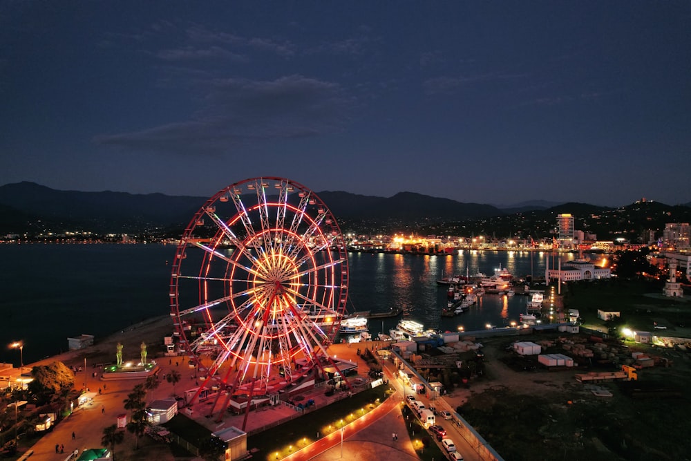 Grande roue près d’un plan d’eau pendant la nuit