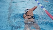 woman in black and white bikini swimming on pool during daytime