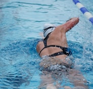 woman in black and white bikini swimming on pool during daytime