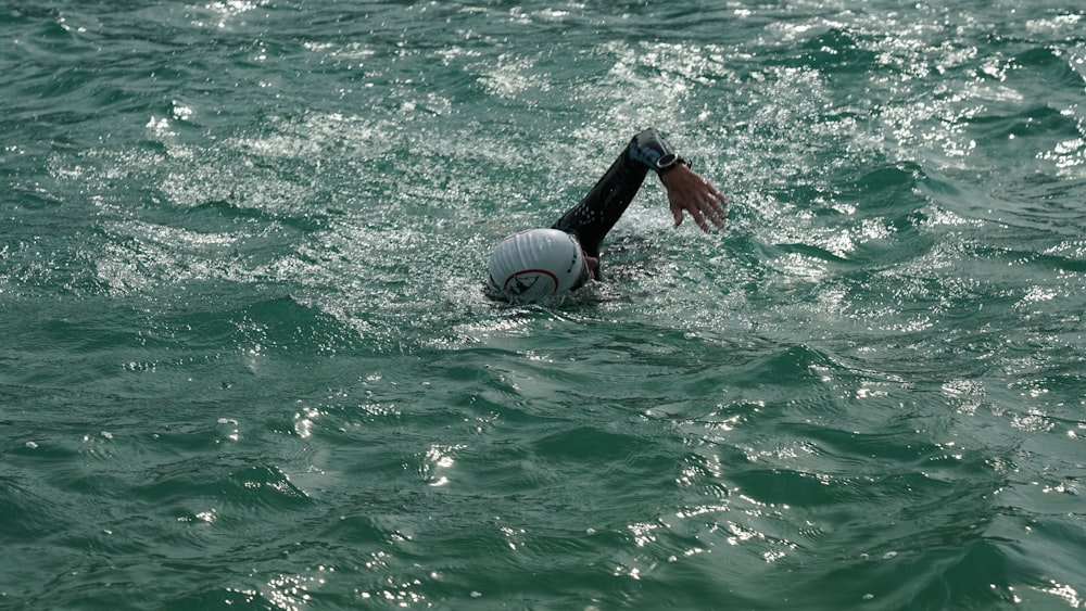 pessoa segurando anel inflável branco e preto na água