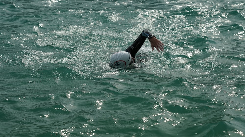 person holding white and black inflatable ring on water