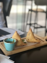 Golden fried samosas filled with spiced meat and vegetables, served with dipping sauce.
