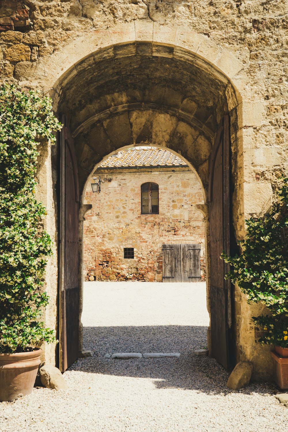 brown concrete arch near green plants during daytime