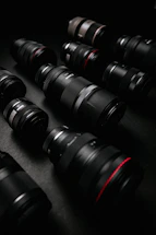 A close-up shot of vintage camera lenses arranged artfully on a dark surface.