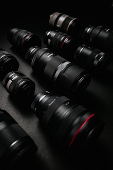 A collection of vibrant camera lenses arranged in a circle on a dark surface.