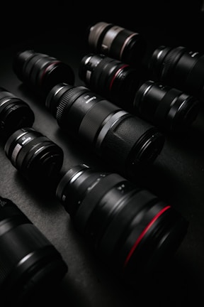 Top-down view of a camera collection arranged neatly on a dark fabric backdrop.