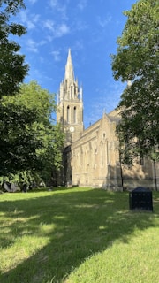 brown concrete church near green trees during daytime