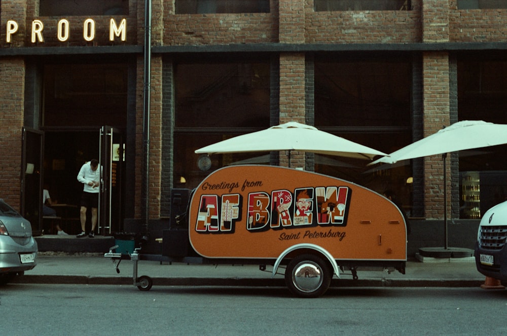 red and white volkswagen t-1 parked beside brown concrete building during daytime