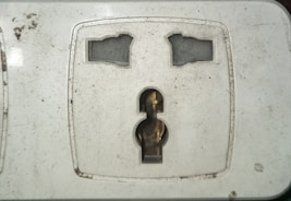 Close-up of electrician repairing a wall socket with care