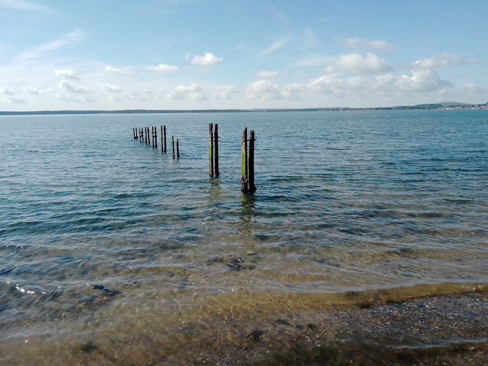 brown wooden dock on sea under blue sky during daytime