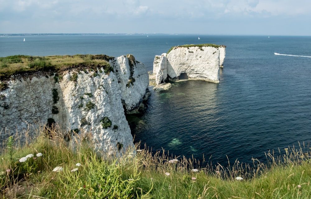 gray rock formation beside body of water during daytime