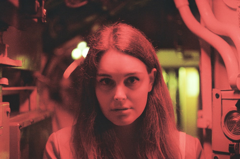 woman in pink shirt with red light on her face