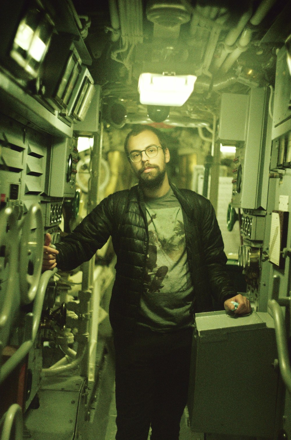 man in black leather jacket standing beside white metal rack