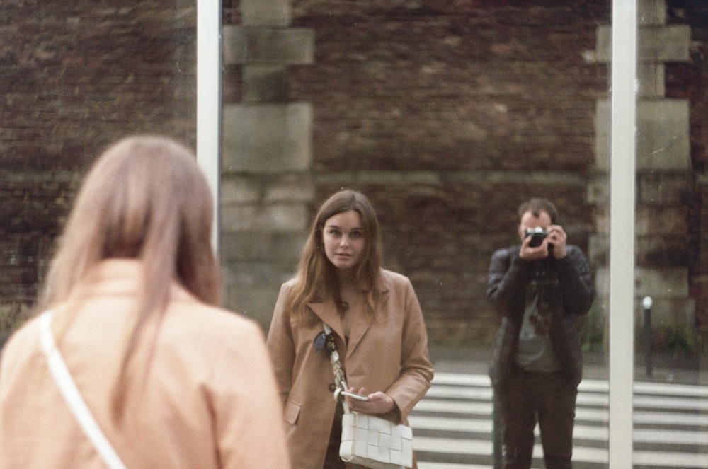 woman in black blazer standing beside woman in beige coat