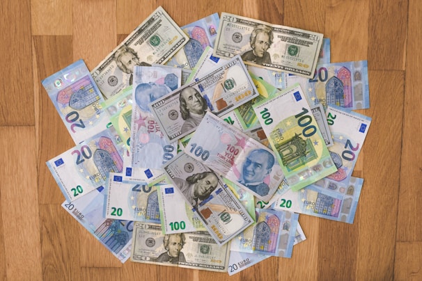 A collection of banknotes displayed on a wooden table.