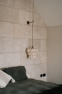 Calm, spacious bedroom with soft stone walls and minimalist decor.