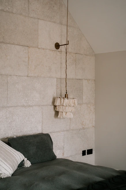 Luxurious bedroom featuring elegant stone wall accents and soft textures