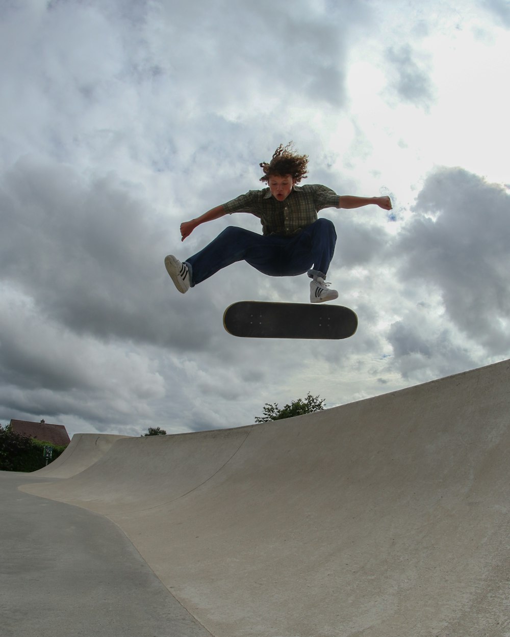 man in black t-shirt and blue denim jeans riding skateboard during daytime