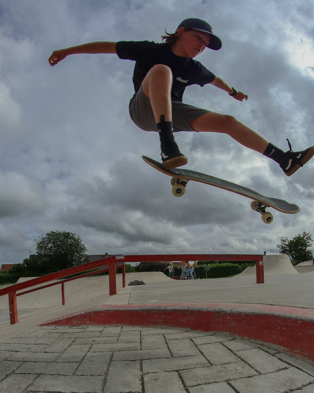 man in black t-shirt and black shorts doing skateboard stunts