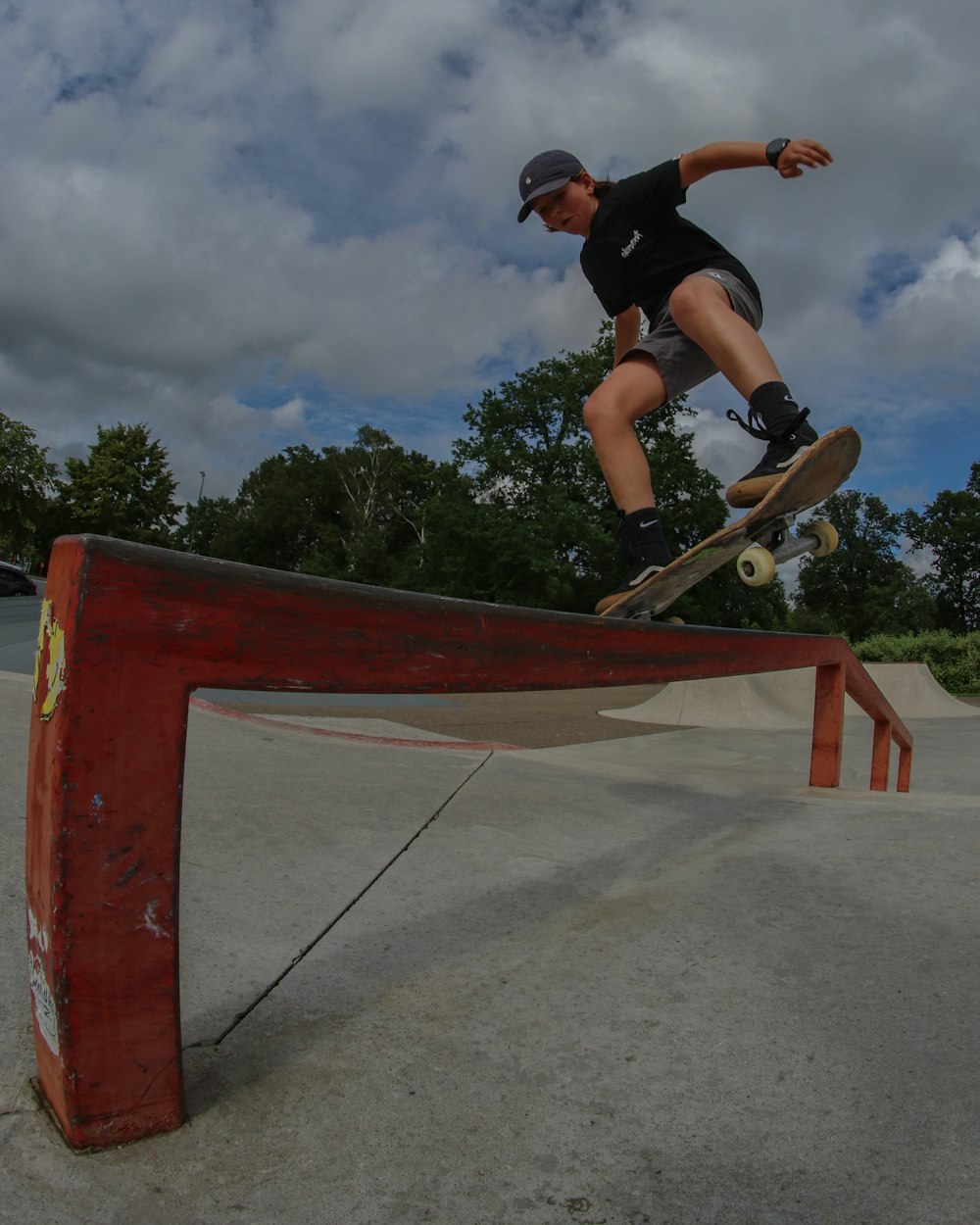 man in black shirt and black shorts doing skateboard stunts on mid air during daytime