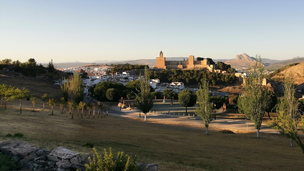 Árboles verdes cerca de edificios de concreto marrón durante el día