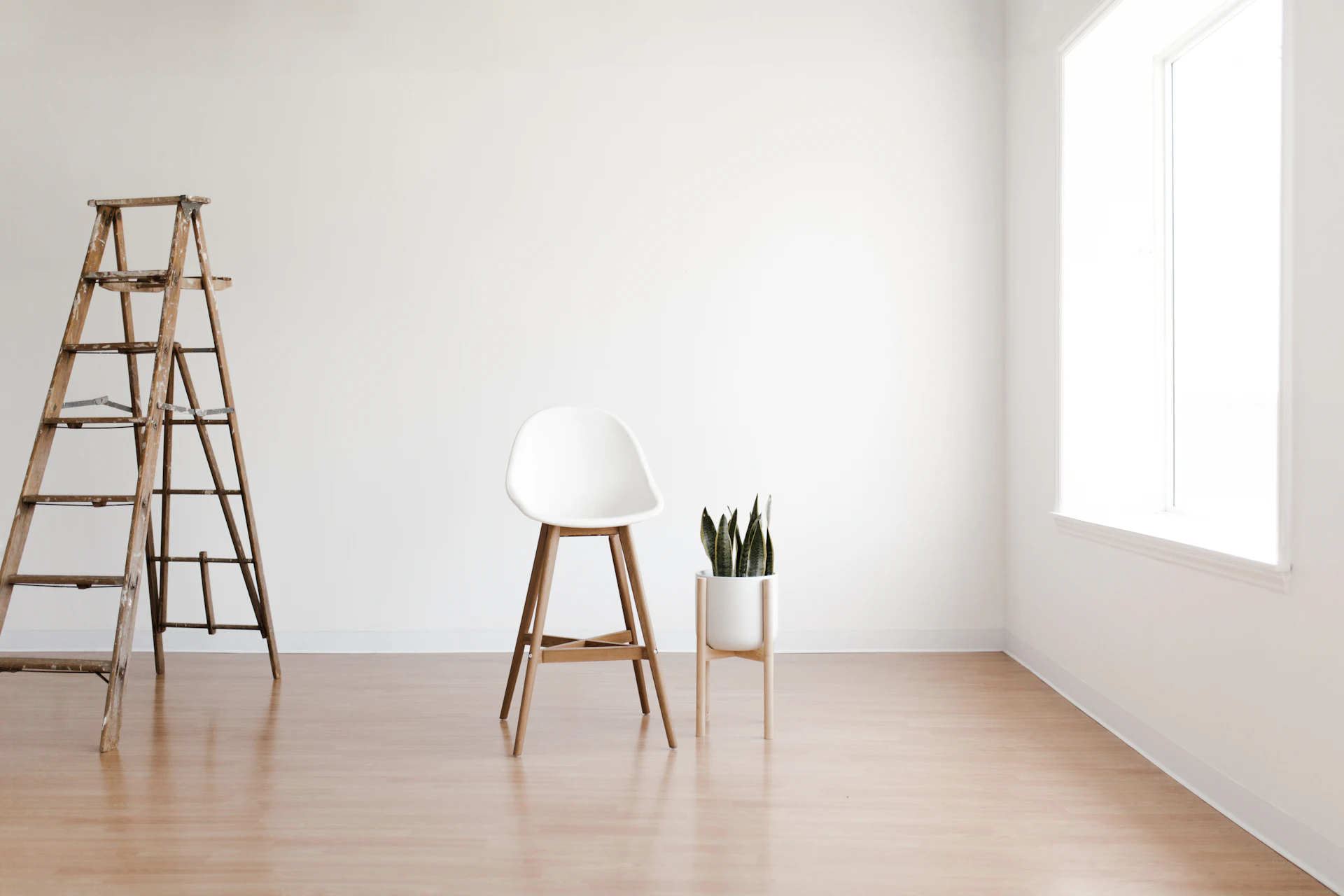 A bright empty room with a wooden ladder ready for decorating
