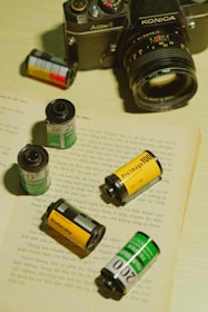 Close-up of a vintage film camera surrounded by scattered movie scripts.