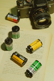 Close-up of a vintage film camera surrounded by scattered movie scripts.