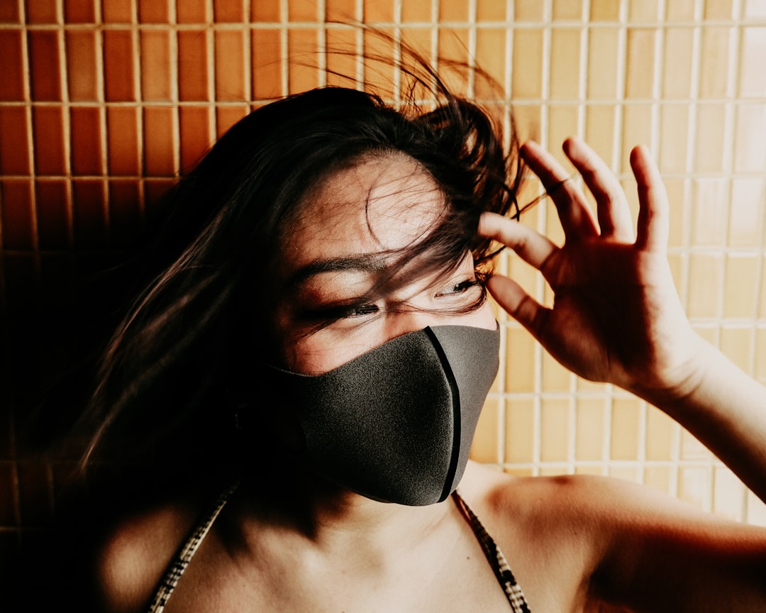 woman in black brassiere covering her face