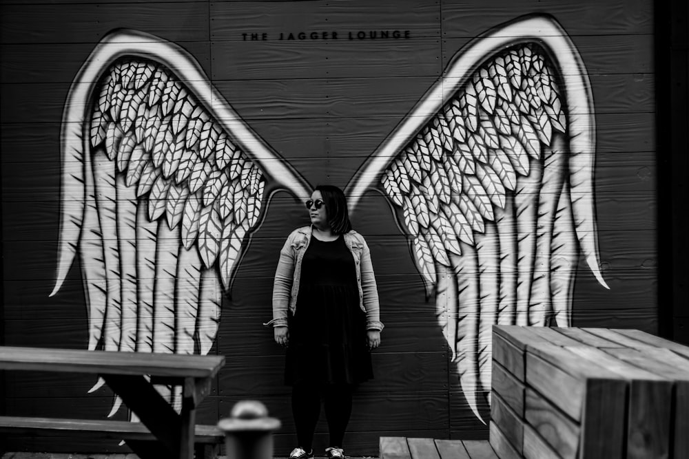 woman in black coat standing on gray concrete stairs