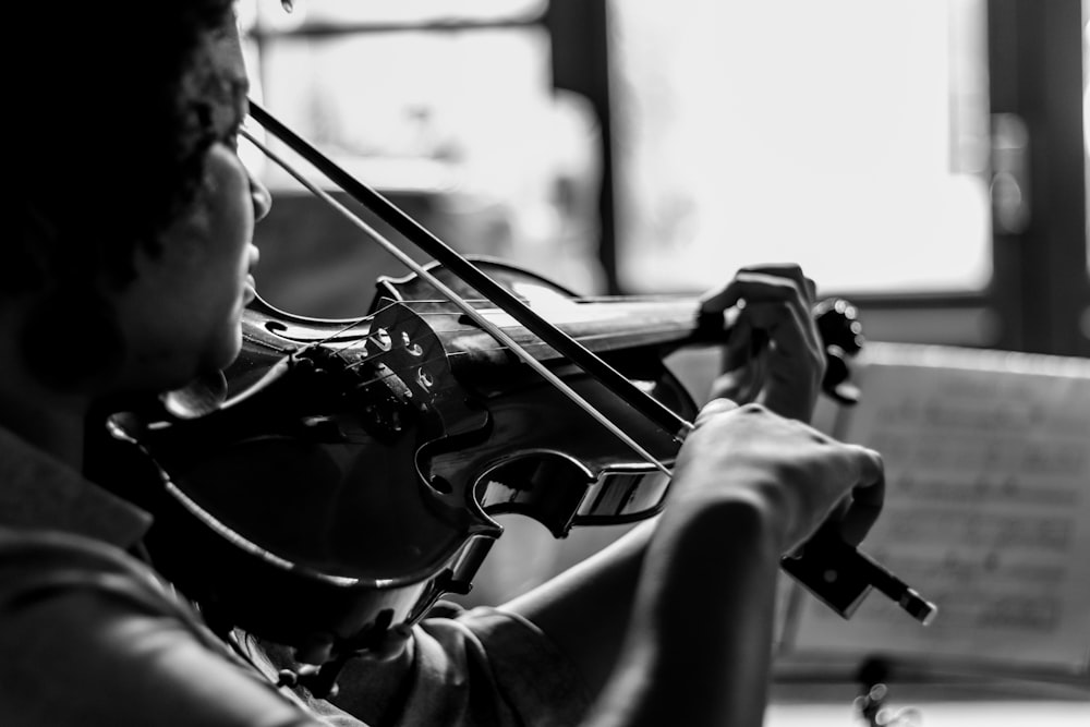 Uomo che suona il violino in scala di grigi