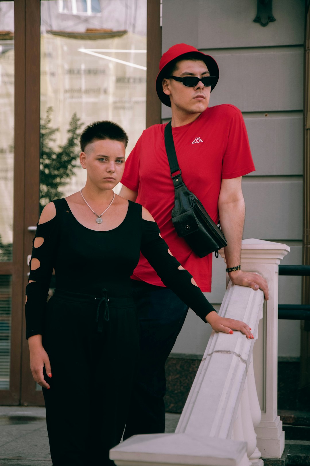 woman in black dress standing beside man in red shirt