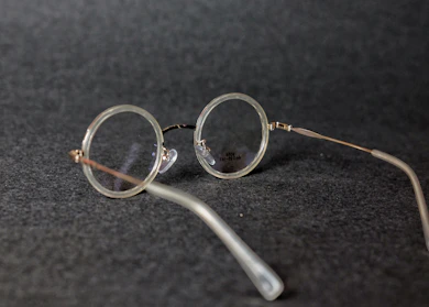 Close-up of stylish eyeglasses with thin frames resting on a marble surface.