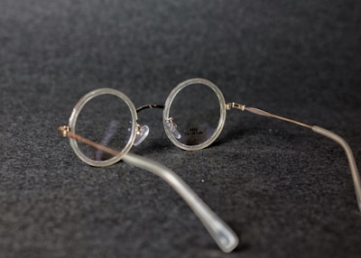 A stylish pair of eyeglasses with thin metal frames resting on a wooden table.