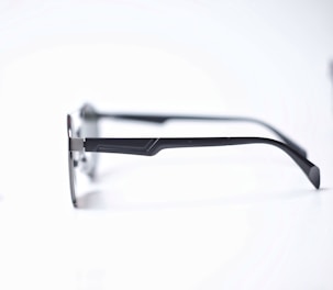 A stylish pair of modern eyeglasses with thin metal frames displayed on a minimalist white background.