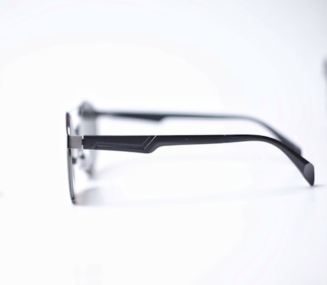 Close-up of sleek, modern eyeglasses with a minimalist frame resting on a wooden surface.