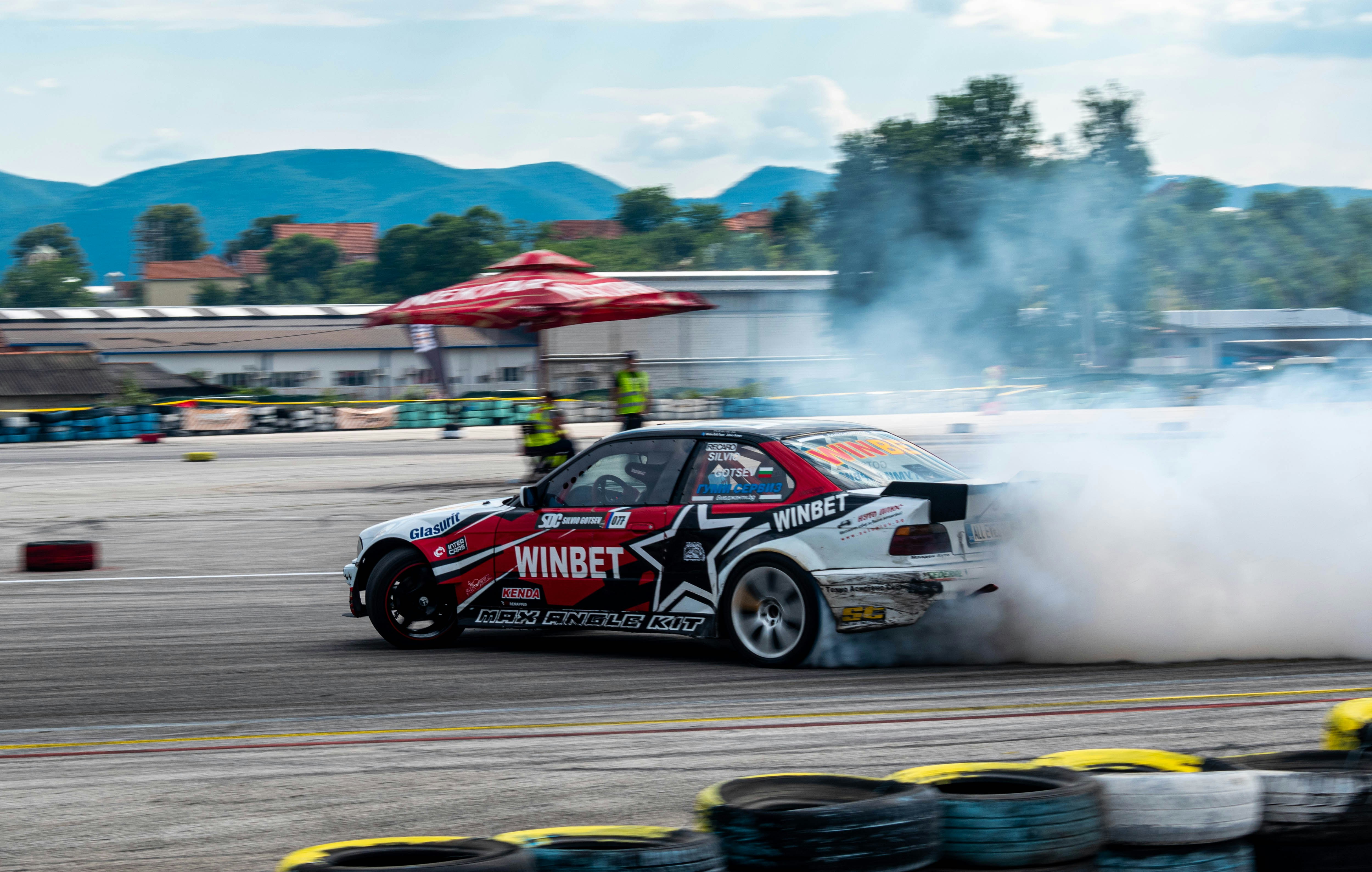 Rot-weißer Rennwagen tagsüber unterwegs