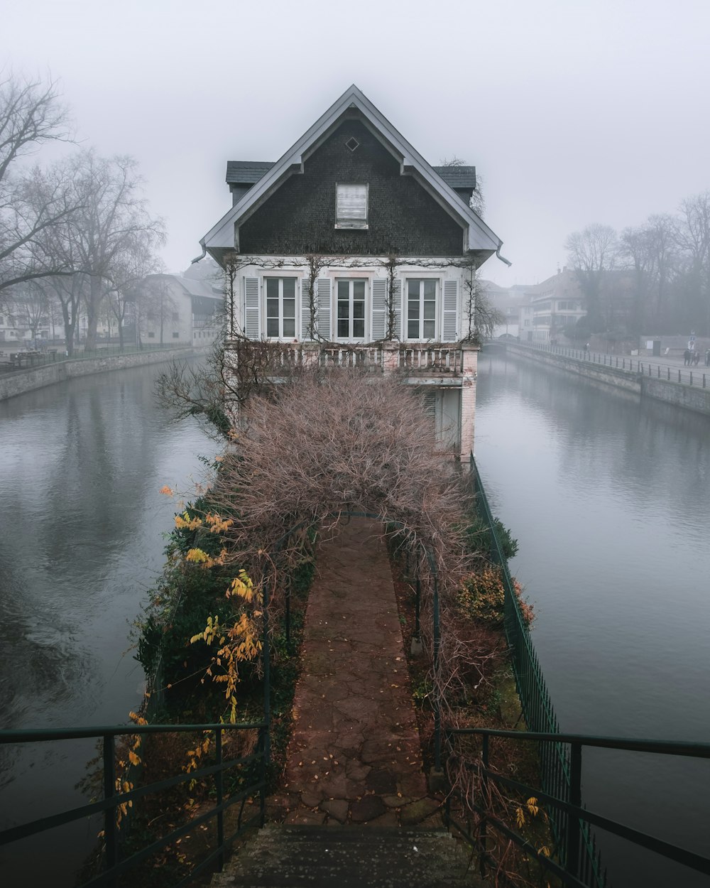 brown and white house beside river during daytime