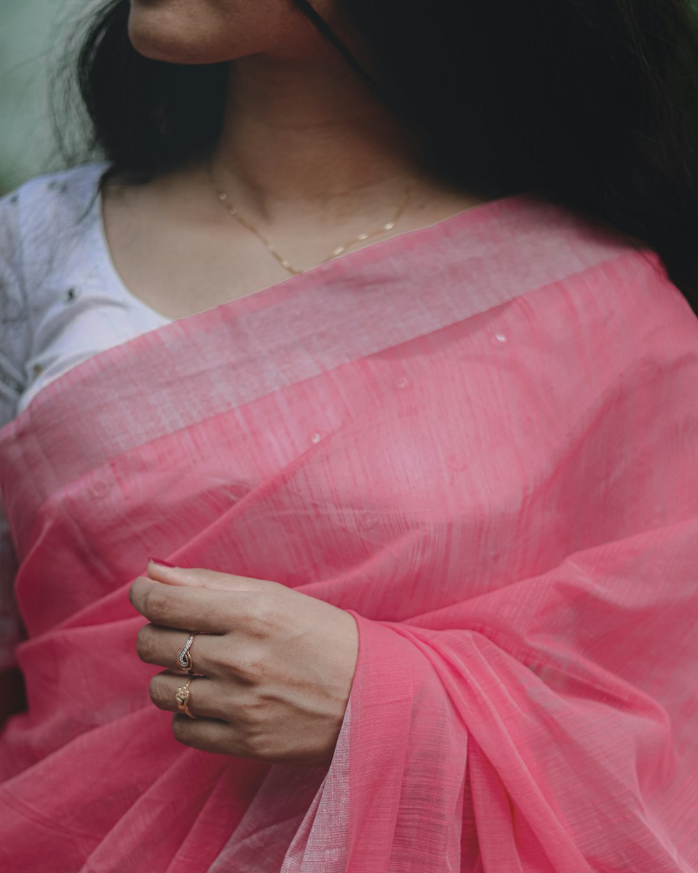 a woman in a pink sari with a ring on her finger