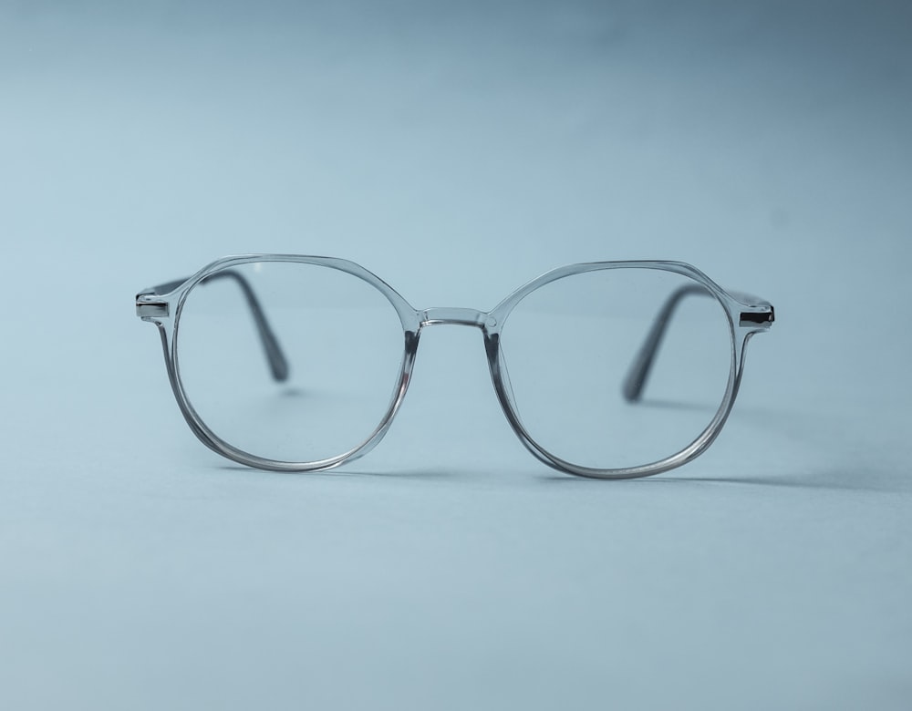 silver framed eyeglasses on white surface