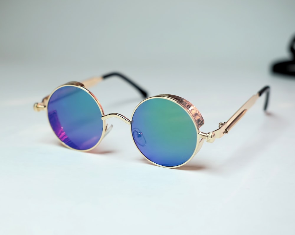 blue framed sunglasses on white surface