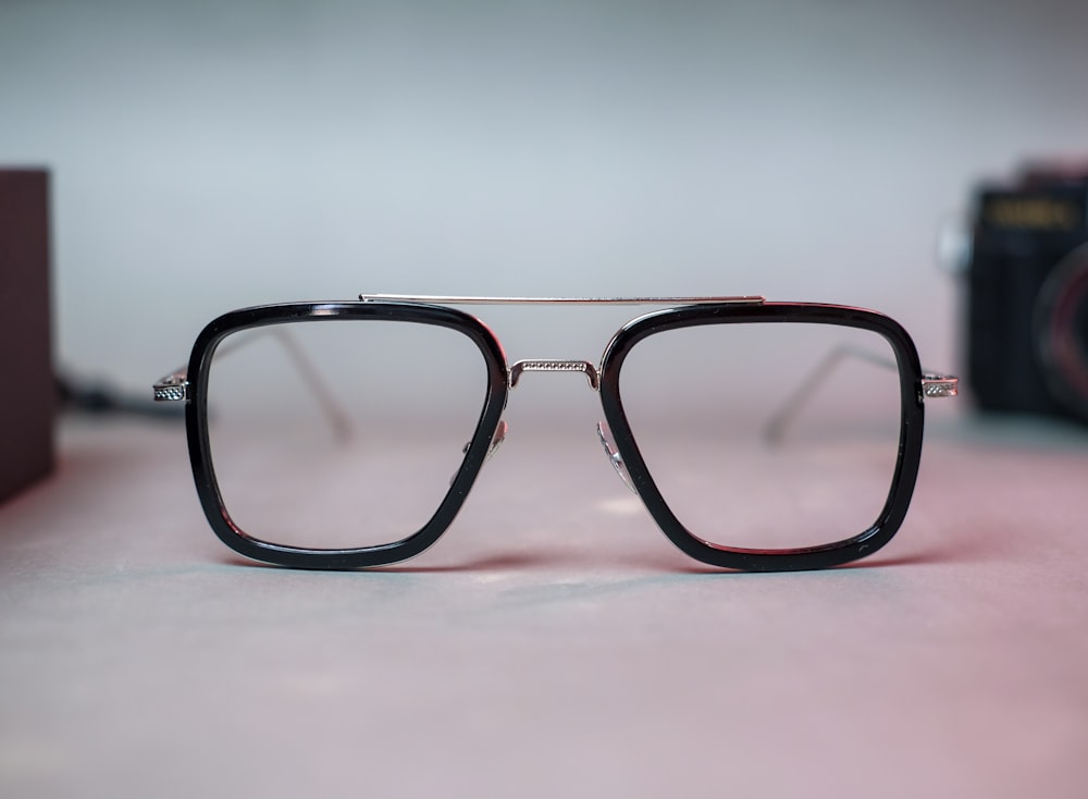 black framed eyeglasses on white surface